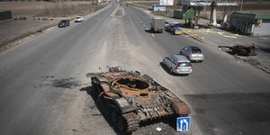 Αυτοκίνητα πολιτών προσπερνούν κατεστραμμένο ρωσικό τανκ στο Κίεβο τον Απρίλιο του 2022