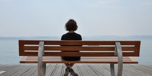 γυναίκα κάθεται μόνη σε παγκάκι