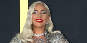 η Lady Gaga χαμογελαστή με ασημένιο φόρεμα