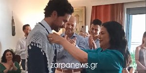 Η Μαρία Τζομπανάκη περνάει το λευκό σαρίκι στους ώμους του γιου της Ορφέα Αυγουστίδη 