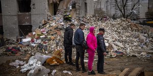 Άνθρωποι στέκονται σε χαλάσματα στην πόλη του Τσερνίχιβ