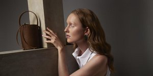 γυναίκα με λευκό φόρεμα και τσάντα