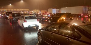 Ουρές αυτοκινήτων σε διόδια νύχτα με βροχή