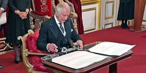 Ο Βασιλιάς Κάρολος τη στιγμή που υπογράφει