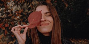Γυναίκα χαμογελάει με φύλλο δέντρου