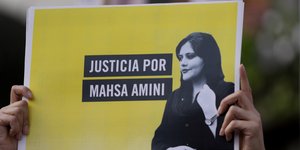 Μια γυναίκα κρατάει μια πινακίδα που γράφει στα ισπανικά Δικαιοσύνη για την Mahsa Amini