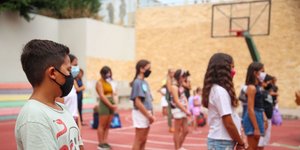 μαθητές με μάσκες λόγω κορωνοϊού σε γήπεδο μπάσκετ σχολείου