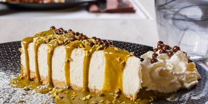 Λαχταριστό cheesecake με επικάλυψη φιστικιού και ψιλοκομμένα φιστίκια Αιγίνης συνοδευόμενα από φρέσκια σαντιγί