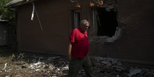 Ο επικεφαλής της μονάδας ταχείας αντίδρασης του Ερυθρού Σταυρού, Τάρας Λογκίνοβ, περπατά μπροστά από κατεστραμμένο κτίριο του Οργανισμού στο Σλαβιάνσκ/ Φωτογραφία αρχείου: AP