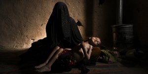 Η Φατιμά κρατά στην αγκαλιά της την υποσιτισμένη κορούλα της στο σπίτι τους στη Χεράτ του Αφγανιστάν
