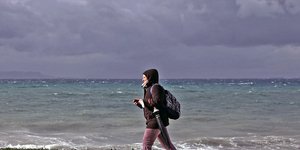 μια κοπέλα προχωρά σε παραλία το χειμώνα