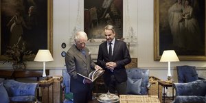 Μητσοτάκης και Κάρολος κοιτάζουν βιβλίο στα ανάκτορα του Τατοϊου