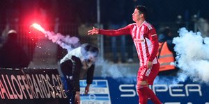 Ο Χάμες Ροντρίγκες του Ολυμπιακού απομακρύνει φωτοβολίδα από τον αγωνιστικό στον εκτός έδρας αγώνα με τον ΠΑΣ Γιάννινα