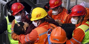 Διασώστες μεταφέρουν έναν ανθρακωρύχο που είχε παγιδευτεί σε ορυχείο