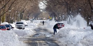 Κόσμος καθαρίζει τον δρόμο από το χιόνι