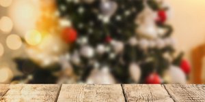 Ξύλινο τραπέζι και στο φόντο στολισμένο χριστουγεννιάτικο δέντρο