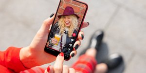 Γυναίκα βλέπει βίντεο του TikTok σε κινητό
