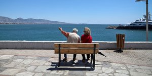 Ενα ζευγάρι ηλικιωμένων κάθεται σε παγκάκι μπροστά στη θάλασσα
