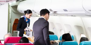 Αεροσυνοδοί και επιβάτες σε αεροπλάνο