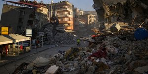 Ανδρας περπατά μέσα σε γκρεμισμένα σπίτια