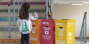 Παιδί μπροστά σε κάδους ανακύκλωσης