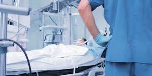 Γιατρός κοιτάζει ασθενή στο κρεβάτι