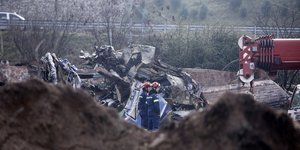 Πυροσβέστες μπροστά από τα συντρίμμια του τρένου στα Τέμπη