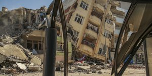 Ένα κατεστραμμένο κτίριο ακουμπά σε ένα γειτονικό σπίτι μετά τον σεισμό στο Samandag, στη νότια Τουρκία