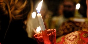 Γυναίκα κρατά λαμπάδα γιορτάζοντας την Ανάσταση του Κυρίου