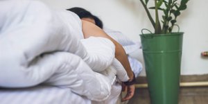 Γυναίκα κοιμάται κάτω από λευκό πάπλωμα