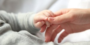Μητέρα κρατά το χέρι του μωρού της