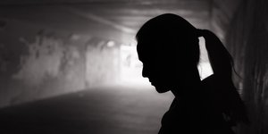 θλιμμένη νεαρή γυναίκα που στέκεται σε σκοτεινό τούνελ