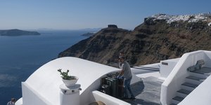 Τουρίστας κουβαλάει αποσκευές στη Σαντορίνη