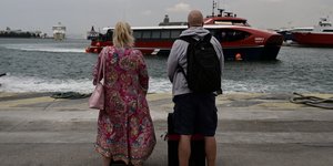 Τουρίστες στον Πειραιά που ετοιμάζονται για απόδραση, βλέπουν συννεφιασμένο ουρανό και βροχή