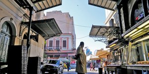 Ενας κρεοπώλης μπροστά στην είσοδο της Βαρβακείου αγοράς