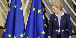 Η Ούρσουλα φον ντερ Λάιεν κοιτά τις σημαίες της ΕΕ