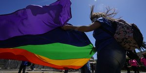 Γυναίκα κρατά σημαία των ΛΟΑΤΚΙ