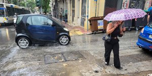 Γυναίκα περπατά στη βροχή με ομπρέλα