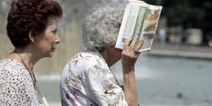 Ηλικιωμένη προφυλάσσεται με εφημερίδα από τον ήλιο