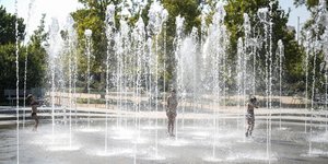 Παιδιά δροσίζονται εν μέσω καύσωνα σε συντριβάνι στο ΚΠΙΣΝ στην Αθήνα