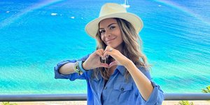 Η Μαρία Μενούνος με τζιν φόρεμα μπροστά σε ηλιοβασίλεμα