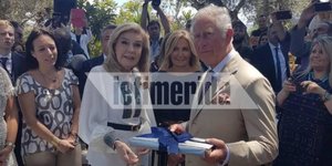 Η Μαριάννα Βαρδινογιάννη δωρίζει το βιβλίο της στον Κάρολο υπό το βλέμμα της Μαρέβα Μητσοτάκη