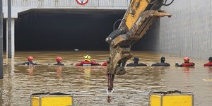 Διασώστες αναζητούν επιζώντες κατά μήκος ενός δρόμου που βυθίστηκε από τα πλημμυρικά ύδατα και οδηγεί σε μια υπόγεια σήραγγα στην πόλη Cheongju της Νότιας Κορέας
