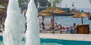 κόσμος σε παραλία λόγω ζέστης συντριβάνι
