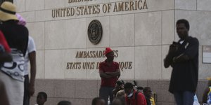 Άνθρωποι που εκτοπίστηκαν από ένοπλες συμμορίες από τα σπίτια τους στη συνοικία Tabare, στέκονται έξω από την πρεσβεία των ΗΠΑ στο Πορτ-ο-Πρενς της Αϊτής