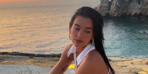 Η Dua Lipa με λευκά ρούχα πάνω σε βράχια