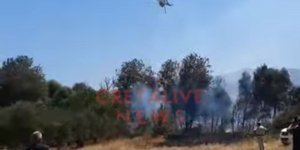 Ελικόπτερο ρίχνει νερό σε φωτιά σε βλάστηση