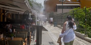 Γυναίκα περπατά εν μέσω καύσωνα στην Αθήνα 