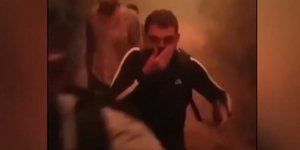 Μετανάστης καλύπτει το πρόσωπό του λόγω το καπνού