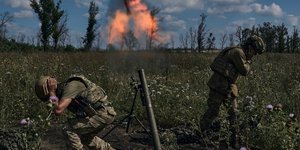 Ουκρανοί στρατιώτες ρίχνουν οβίδα και κλείνουν τα αυτιά τους
